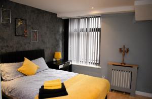 a bedroom with a bed and a cross on the wall at Heart of Leeds - 2 Bedroom Flat in Leeds