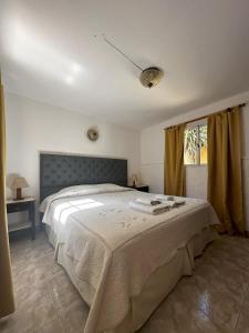 une chambre avec un grand lit et une fenêtre dans l'établissement Cabañas el Pinar, à Huerta Grande