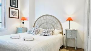 Un dormitorio con una gran cama blanca con dos lámparas. en Chambre calme vue jardin, en Choisy-le-Roi