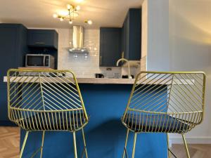 two chairs sitting in front of a kitchen counter at Newcastle City Apartments - FREE Parking Baltic Quay in Gateshead