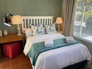 a bedroom with a large bed with towels on it at Joy@Grotto Beach, Hermanus in Hermanus