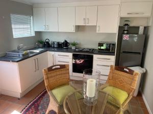 a kitchen with a table and chairs and a refrigerator at Joy@Grotto Beach, Hermanus in Hermanus