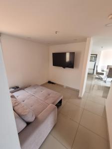 sala de estar con sofá y TV de pantalla plana en Cómodo apartamento, en Medellín