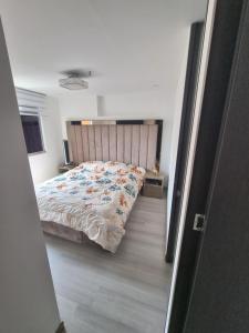 een slaapkamer met een groot bed met een houten hoofdeinde bij Cómodo apartamento in Medellín