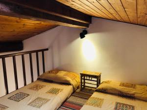 1 Schlafzimmer mit 2 Betten und Holzdecke in der Unterkunft Il Borghetto sul Golfo in Magazzini