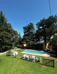 - une piscine entourée d'un groupe de chaises dans l'établissement Cabañas el Pinar, à Huerta Grande