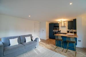 a living room with a blue couch and a kitchen at Newcastle City Apartments - FREE Parking Baltic Quay in Gateshead