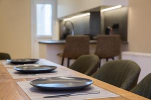 une table en bois avec des plaques noires au-dessus dans l'établissement Urban Spacious Apartment Near Kallimarmaron, à Athènes