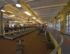 a gym with a row of treadmills and machines at The Retreat House, Olathe in Olathe