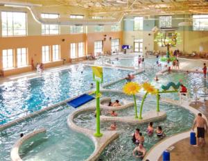 a large swimming pool with many people in it at The Retreat House, Olathe in Olathe