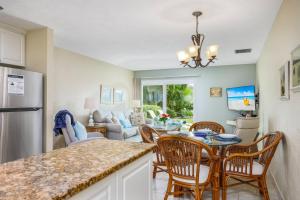 a kitchen and living room with a table and chairs at Jamaica Royale Beach Happiness in Siesta Key