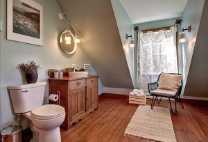 een badkamer met een toilet, een wastafel en een raam bij J&K Lakehouse in Saint-Jean-de-Matha