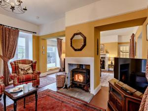 a living room with a fireplace and a couch at 3 Bed in Alston 89994 in Slaggyford