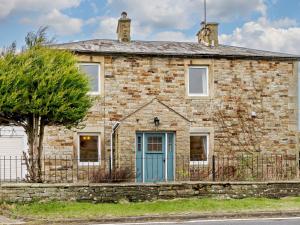 una vieja casa de piedra con una puerta azul en 3 Bed in Alston 89994, en Slaggyford