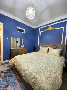 Dormitorio azul con cama y pared azul en Appartement meublé Tanger en Tánger