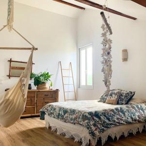La Ferme Pouchuc في Bénesse-Maremne: غرفة نوم مع أرجوحة معلقة من السقف