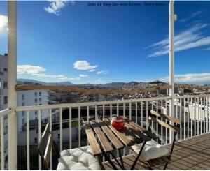 a balcony with a wooden bench and a view of a city at LaFrenchCasa Clandestina in Marseille