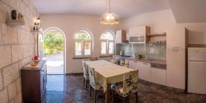 Apartment Curri في بوتشيتشا: مطبخ مع طاولة مع كراسي وغرفة طعام