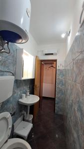 a bathroom with two toilets and a sink at Red gold apartment in Pula +14 photos