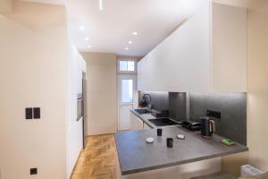 une cuisine avec des armoires blanches et un comptoir dans l'établissement Urban Spacious Apartment Near Kallimarmaron, à Athènes