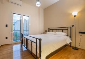 une chambre avec un lit et une grande fenêtre dans l'établissement Urban Spacious Apartment Near Kallimarmaron, à Athènes 46 autres photos