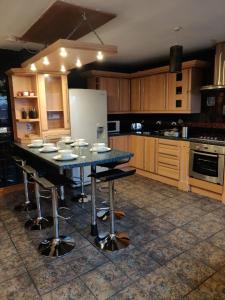 een keuken met een tafel met stoelen en een koelkast bij Super 7Bed House - Hot Tub - Large Gathering Meets in Headingley