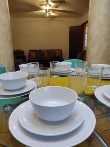 een tafel met witte kommen en borden en glazen bij Super 7Bed House - Hot Tub - Large Gathering Meets in Headingley