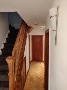 a hallway with a staircase and a wooden stair case at Super 7Bed House - Hot Tub - Large Gathering Meets in Headingley