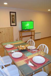 una mesa con placas blancas y una TV en una habitación en Casa Llao alojamiento de montaña en San Carlos de Bariloche