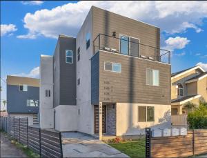 una casa grande con una valla delante en Modern 3BR Home in Mid-City, en Los Ángeles