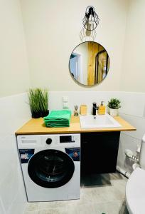 a bathroom with a washing machine and a sink at Olivia Apartments - Słoneczny apartament w centrum Warszawy, Plac Unii Lubelskiej, Łazienki Królewskie, Pole Mokotowskie - 24h check-in in Warsaw