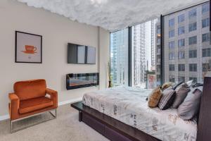 a bedroom with a bed and a chair and a large window at Lenox Mall Buckhead City Views in Atlanta