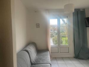 a living room with a couch and a window at Studio - 4 pers. 10min Disney in Bussy-Saint-Georges