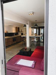 uma sala de estar com um sofá vermelho e uma cozinha em Dunes de Blankenberge - Luxurious Open Loft apartment em Blankenberge