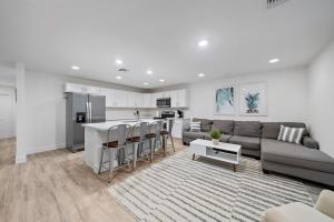 a living room with a couch and a kitchen at New! Few Minutes To Downtown, 10 To The Beach! in West Palm Beach