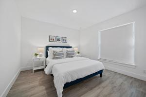 a white bedroom with a bed and a window at New! Few Minutes To Downtown, 10 To The Beach! in West Palm Beach