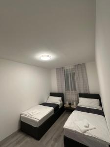 two beds in a small room with white walls at Familien Apartment in Niederaigen