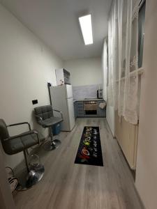 uma cozinha com um frigorífico, 2 cadeiras e um tapete em Familien Apartment em Niederaigen