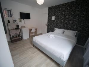 um quarto com uma grande cama branca e uma parede em NG SuiteHome l Lille l Roubaix Gare l Cassel - Netflix - Wifi em Roubaix