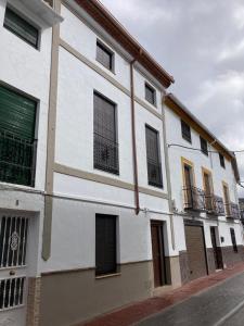 - un bâtiment blanc avec des fenêtres donnant sur une rue dans l'établissement LA BUENA ESTRELLA, à Arbuniel