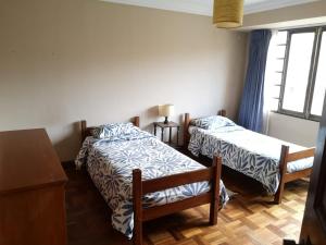 1 Schlafzimmer mit 2 Betten, einem Tisch und einem Fenster in der Unterkunft Departamento espacioso in La Paz