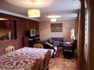 ein Schlafzimmer mit einem Bett und ein Wohnzimmer in der Unterkunft Departamento espacioso in La Paz