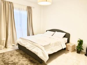- une chambre avec un lit doté de draps blancs et une fenêtre dans l'établissement Madinaty Luxury Elite Apartment, au Caire