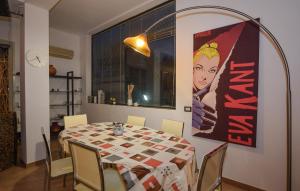 a dining room with a table and a poster on the wall at 3 Bedroom Nice Apartment In Comiso in Comiso