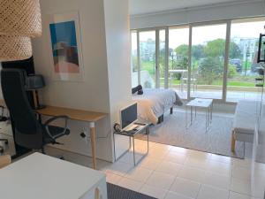 1 dormitorio con 1 cama y escritorio con ordenador en ღ La Corniche • Grand Studio, Piscine & Parking, en La Rochelle