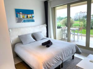 a bed with a stuffed animal on it in a bedroom at ღ La Corniche • Grand Studio, Piscine & Parking in La Rochelle +14 photos