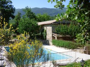 un jardin avec une piscine et une maison dans l'établissement Hôtel Lou Caleù restaurant le Rocher des Abeilles, à Saint-Martin-de-Castillon