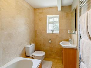 baño con aseo y lavabo y ventana en 1 bed property in Easingwold 84002, en Crayke