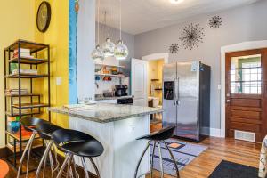 a kitchen with a counter with stools and a refrigerator at Retro-Inspired Indy Home Walk to Fountain Square! in Indianapolis