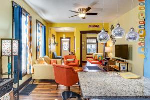 a living room with yellow walls and orange chairs at Retro-Inspired Indy Home Walk to Fountain Square! in Indianapolis